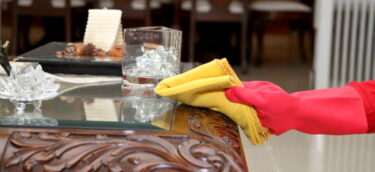 gettyimages-1250681255-612x612 Dusting and cleaning with yellow fabric duster while wearing red color rubber gloves.